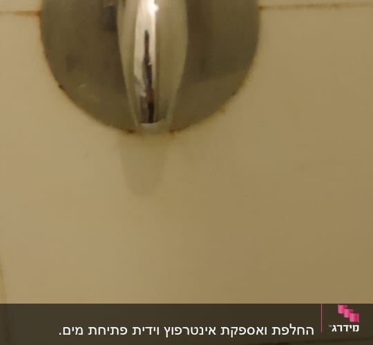 ברז מתכת עגול עם ידית כסופה על קיר